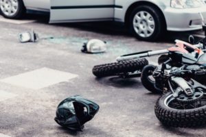 Wrecked helmet and motorcycle on the road due to accident.