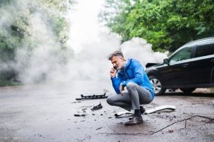 A man on a phone call after a car crash.