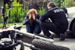 terrified victim of a motorcycle accident interviewed by a police officer.